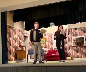 Actors performing a scene during a theatrical rehearsal or play.